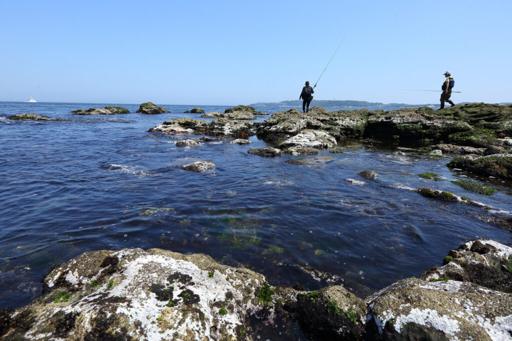 Scenic view of Sarushima Island, Yokosuka, a popular spot for fishing with diverse coastal terrain and historic remnants of its past as a naval fortress, including brick tunnels and gun emplacements.