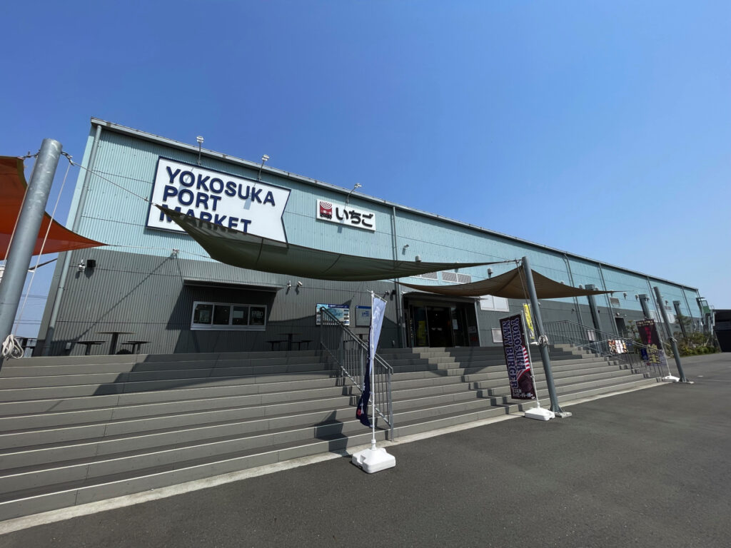 Exterior of Yokosuka Port Market with wide stairs leading to the entrance under a clear blue sky.